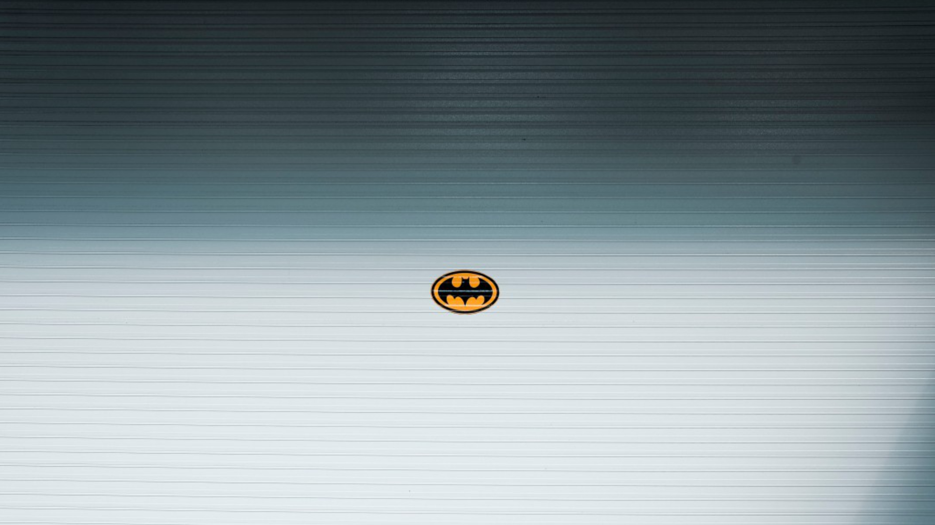 Das gelbe Fledermausemblem von Batman auf einem hellgrauen Rolltor